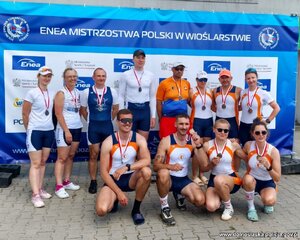 Biorący udział w zawodach pozują do zdjęcia z medalami na szyjach.