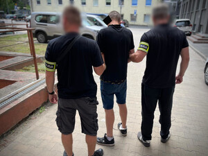 Dwaj policjanci z zatrzymanym mężczyzną.