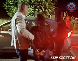 Dwaj policjanci prowadzą zatrzymanego do nieoznakowanego radiowozu.