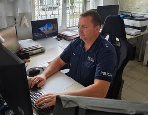 policjant siedzi przy biurku.