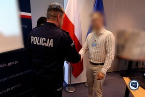 Funkcjonariusz podaje dłoń mężczyźnie gratulując.