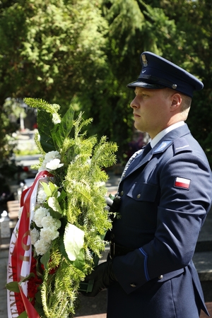 Funkcjonariusz niesie wieniec.