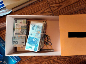 Na dnie pudełka leżą banknoty.