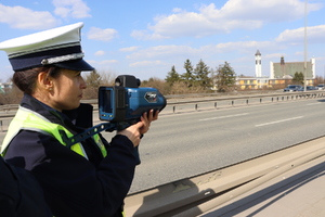 Policjant z ręcznym miernikiem prędkości.