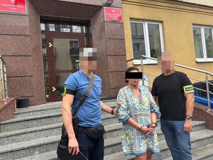 dwóch policjantów stoi z zatrzymaną.