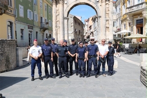 Grupa funkcjonariuszy z Polski i innych krajów podczas wspólnego patrolu pozuja do zdjęcia.