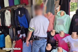 Policjant podczas zabezpieczania podrobionej odzieży.