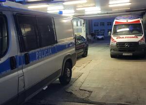 Po prawej stronie radiowóz policyjny, w głębi karetka pogotowia.