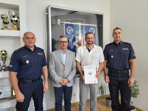 Dwaj policjanci i daj mężczyźni pozują do zdjęcia.