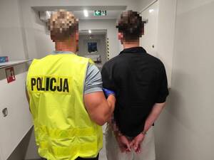 Zatrzymany prowadzony przez policjanta.