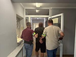 Policjanci prowadzą zatrzymanego.