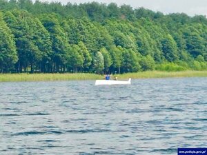 Osoby na przewróconej łodzi.