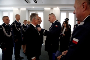 Komendant Główny Policji przypina medal Szefowi Europolu.