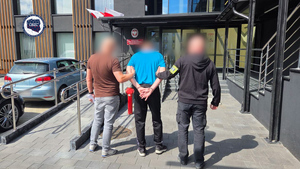 Policjanci prowadzą zatrzymanego.