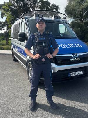 Policjant przed radiowozem.