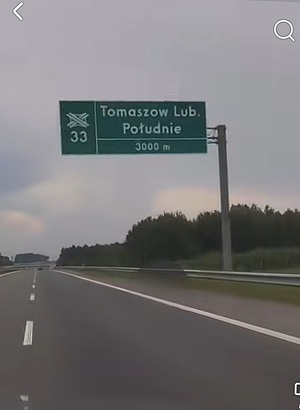 Znak drogowy nad drogą ekspresową informujący o węźle nr 33 Tomaszów Lubelski Południe.