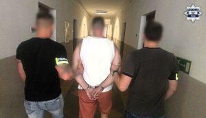 Dwaj policjanci prowadzą zatrzymanego.
