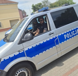 dwóch policjantów siedzi w radiowozie.