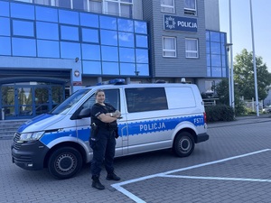 Policjantka przed radiowozem.