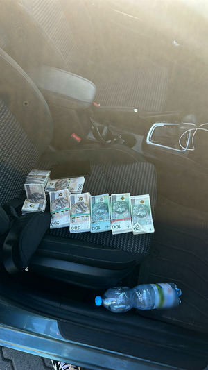 Pieniądze leżą na siedzeniu w samochodzie osobowym.