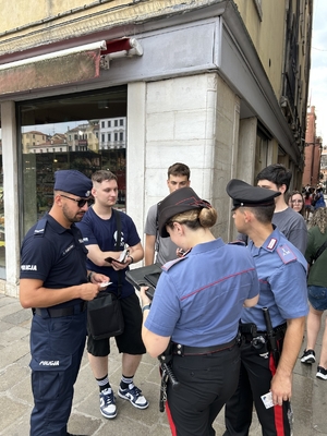 Polscy i włoscy policjanci rozmawiają z turystami.