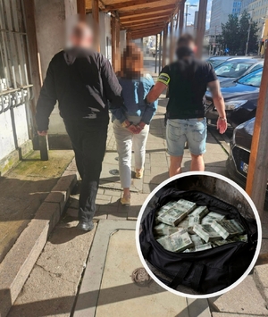 Dwaj policjanci prowadzą zatrzymaną osobę.