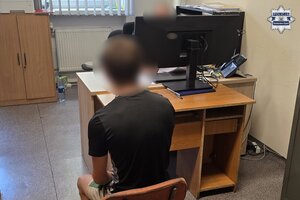 Zatrzymany siedzi na krześle podczas przesłuchania.