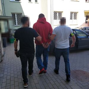 Policjanci prowadzą zatrzymanego.