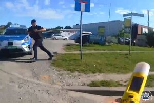 Stopklatka z nagrania. Policjant biegnie do radiowozu.
