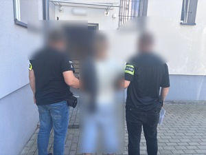 Policja prowadzi zatrzymanego mężczyznę.