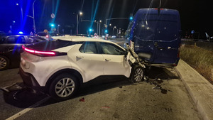 Biała Toyota z uszkodzonym przodem po uderzeniu w busa.