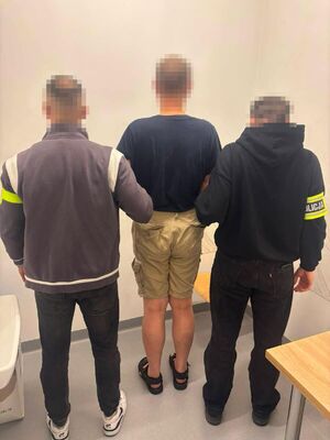Zatrzymany prowadzony przez policjantów.