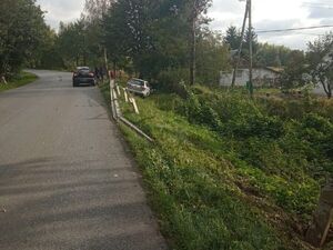 Droga, na niej widać zaparkowane auto, w rowie kolejne białe auto.