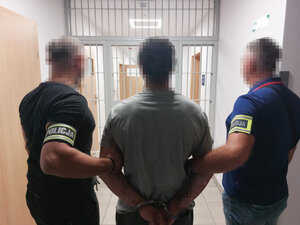 Funkcjonariusze policji zatrzymują mężczyznę.
