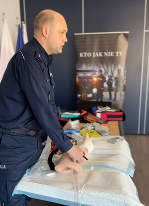 Policjant ćwiczy udzielanie pierwszej pomocy na manekinie.