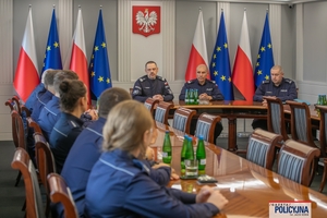 I Zastępca Komendanta Głównego Policji ściska dłoń funkcjonariuszowi gratulując.