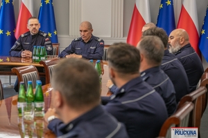 I Zastępca Komendanta Głównego Policji ściska dłoń funkcjonariuszowi gratulując.