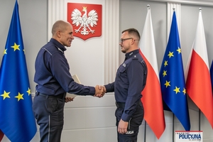 I Zastępca Komendanta Głównego Policji ściska dłoń funkcjonariuszowi gratulując.