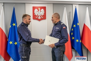 I Zastępca Komendanta Głównego Policji ściska dłoń funkcjonariuszowi gratulując.