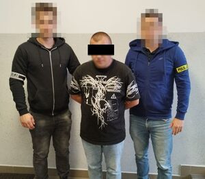 Dwaj policjanci z zatrzymanym mężczyną.