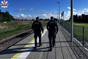 Policjant i strażnik ochrony kolei na peronie.