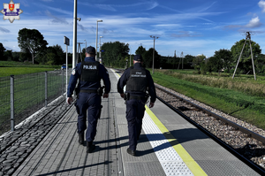 Policjant i strażnik ochrony kolei na peronie.