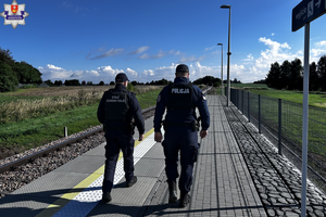 Policjant i strażnik ochrony kolei na peronie.