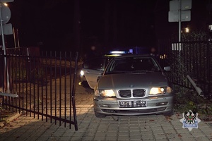 Samochód osobowy przy otwartej bramie.