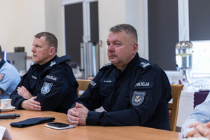 dwóch policjantów siedzi przy biurku.