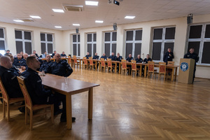 zdjęcie sali. przy stołach siedzą policjanci.