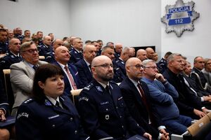 policjanci siedzą na trybunie sali.