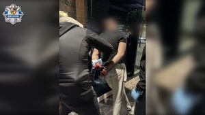 Policjant w cywilu zatrzymuje mężczyznę.