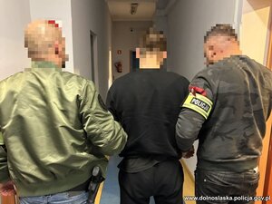 Policjanci prowadzą zatrzymanego.