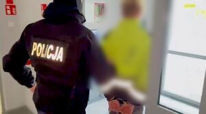 Policjant z zatrzymanym - widok z tyłu.